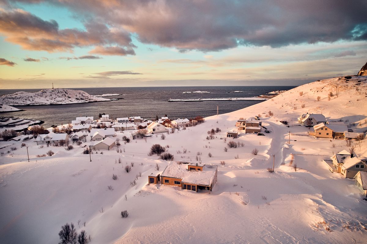 The house above the sea in Reine, snow on the slope down to the water