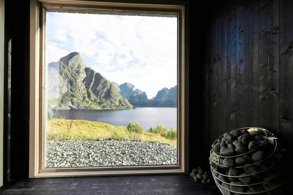 Inside the sauna hut: the sauna stove next to the big window looking out over Reinefjord and the mountains around it