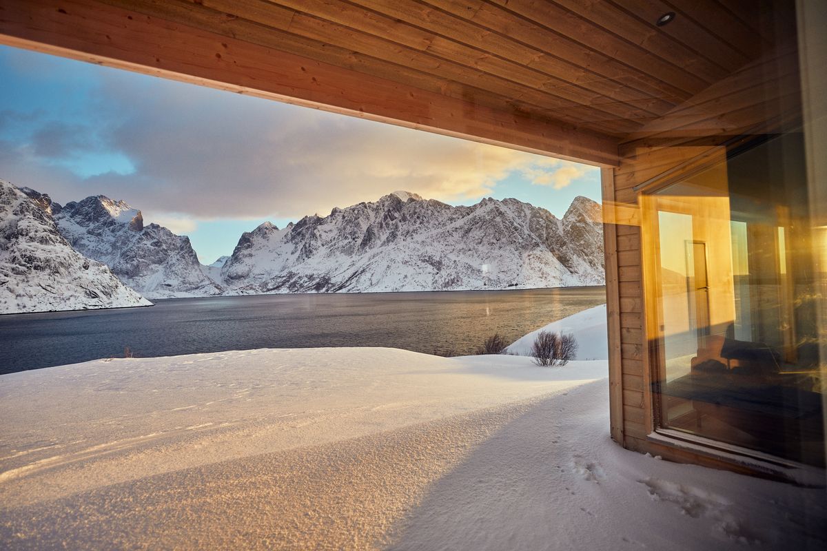 Snow-covered terrace of the Reine house looking out to mountains and water