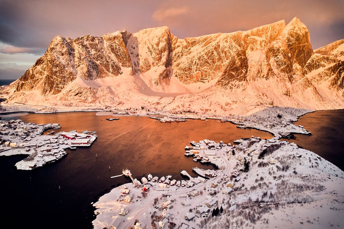 The Reinefjord in winter from above, snowy mountains rising straight out of dark water
